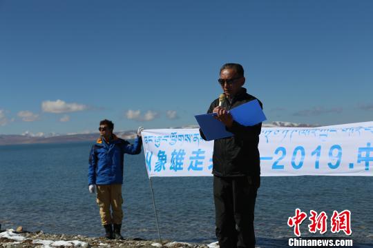 图为团队成员在玛旁雍错湖边读诗。活动方供图