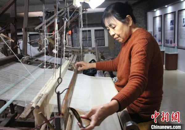 图为工人在使用手工木织机加工传统柳疃丝绸。　赵晓 摄