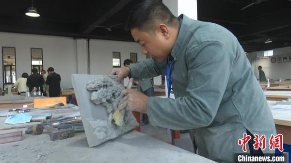 11月11日，在安徽黄山举办的全国砖雕传统技艺大赛上，江苏苏州代表团的苏派砖雕艺人艾礼群正在做最后的清理工作。　刘鸿鹤 摄