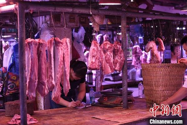 资料图：重庆一农贸市场内的商家挂满充足的猪肉。中新社记者 陈超 摄