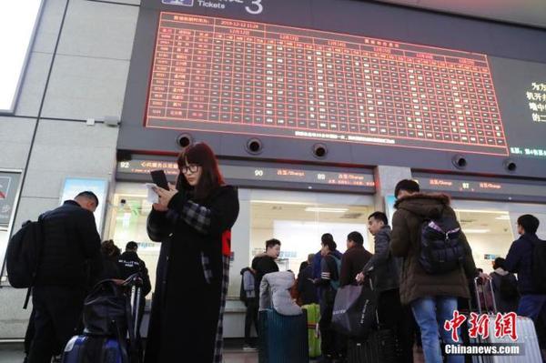 资料图：12月12日，旅客在铁路上海虹桥站排队购买车票。殷立勤 摄