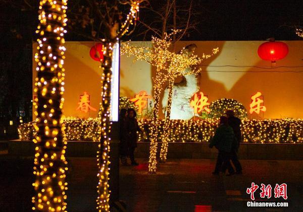 3 1月16日晚间，市民经过北京一处居民小区内的春节灯饰。春节临近，北京年味渐浓。中新社记者 侯宇 摄