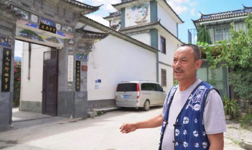 李德昌在自家门口介绍保护传统村落文化的措施（2019年8月10日摄）。
