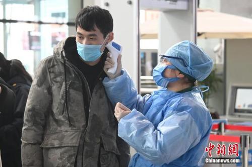 1月27日，受新型冠状病毒感染的肺炎疫情影响，安徽蚌埠南站工作人员为旅客进行体温检测。中新社记者 张兴龙 摄