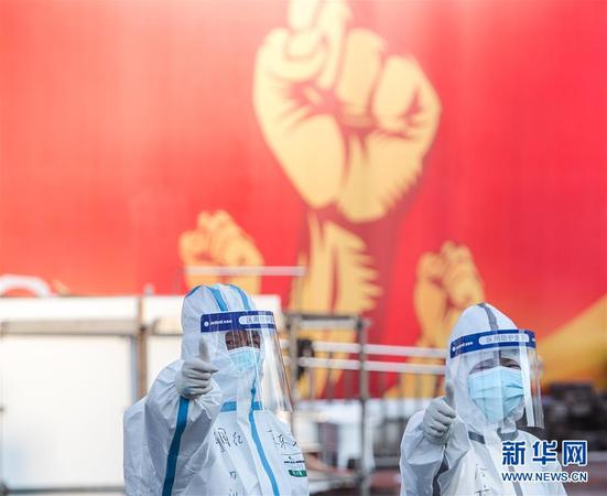 2月12日，两名医务人员在武汉体育中心方舱医院前竖起拇指为自己和同伴加油鼓劲。 新华社记者 肖艺九 摄