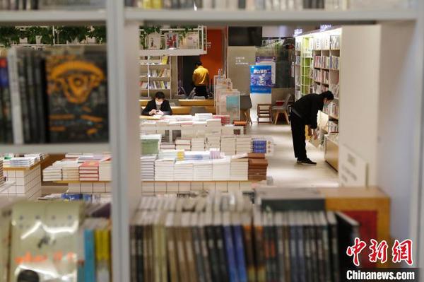 市民戴着口罩在书店挑选书籍。　殷立勤 摄