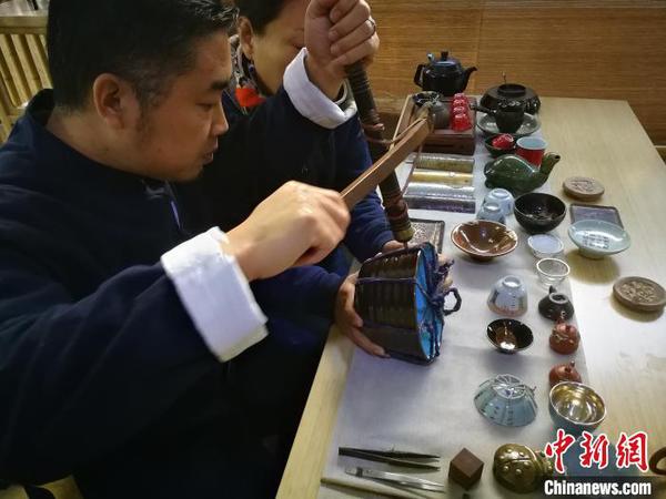 河北省非遗项目锔瓷技艺传承人在展示锔瓷技艺。　李晓伟 摄