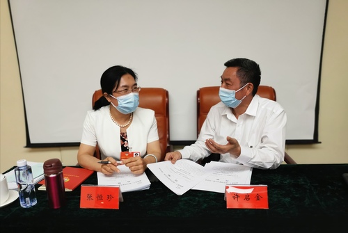张恒珍委员（左）和许启金委员在交流各自提案。 特邀委员记者 皮剑龙 摄