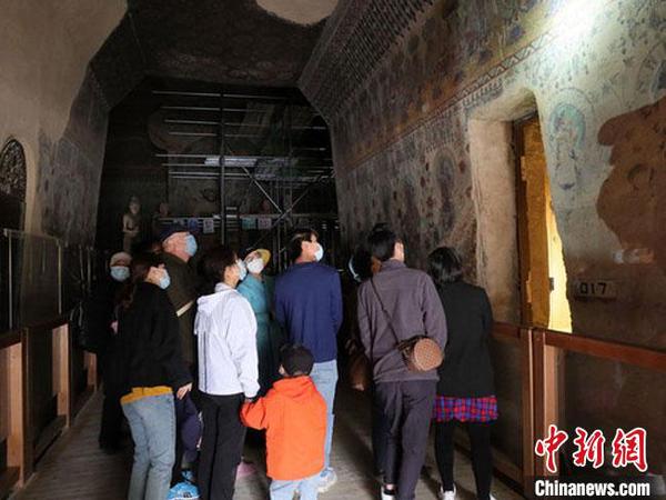 5月10日，游客在敦煌莫高窟洞窟内参观。　孙志军 摄
