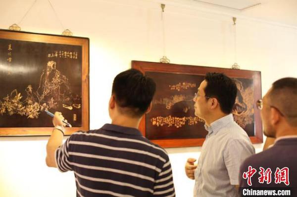 常州统战部副部长汤建忠带领学员们参观徐枫的红木浅刻作品 徐悦 摄