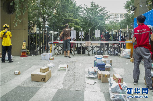 6月17日，快递员在北京市西城区广外街道朗琴园社区等待居民来取件。新华社记者 张玉薇 摄