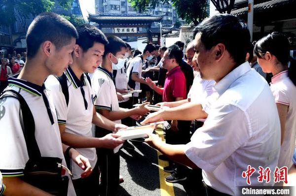 嘉宾向学子代表赠书及状元笔。　记者刘可耕 摄
