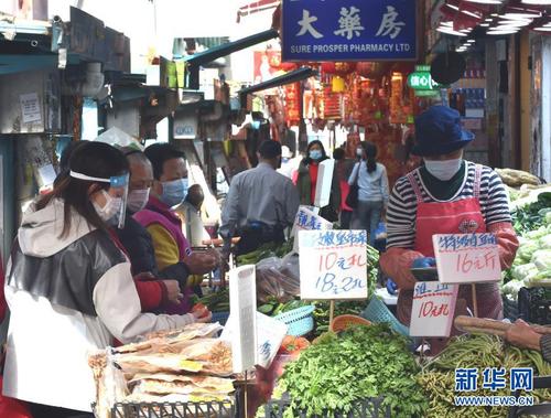 1月21日，戴着口罩的香港市民购买蔬菜。新华社记者 卢炳辉 摄