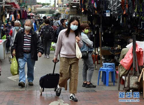 1月21日，戴着口罩的香港市民在马路上行走。新华社记者 卢炳辉 摄