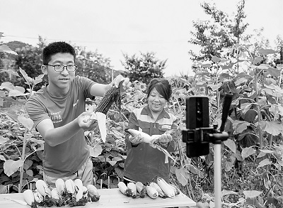 山西平顺县南坡村大学生王亚鹏（左）回村创业成为“新农人”，图为他正在直播销售农产品。新华社发