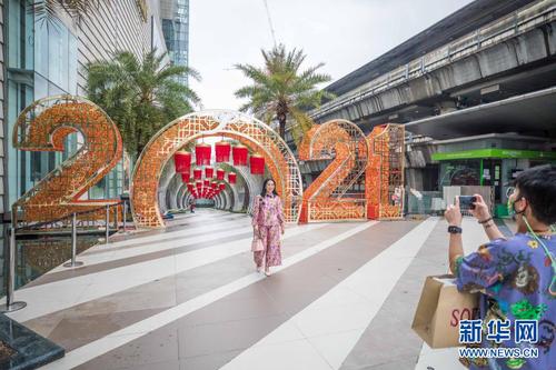 　　2月9日，顾客在泰国曼谷一家商场广场与春节装饰合影。12