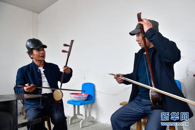 4  2月21日，山庄村秦腔业余剧团的板胡演奏者高忠德（左）、高顺和在演出前试音。