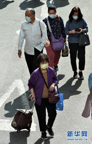 2月23日，香港市民佩戴口罩出行。新华社记者 卢炳辉 摄3