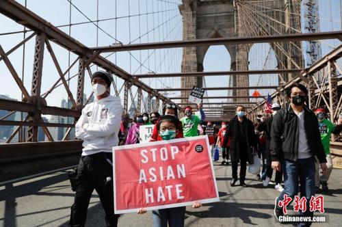 当地时间4月4日，纽约举行反仇恨亚裔大游行，上万民众手持标语在曼哈顿弗利广场集会后，游行穿过布鲁克林大桥至布鲁克林卡德曼广场。图为游行队伍中手持“停止仇恨亚裔”标语的亚裔孩童。 中新社记者 廖攀 摄