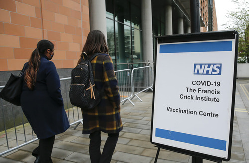 3月18日，人们从英国伦敦一家新冠疫苗接种中心前走过。新华社记者韩岩摄