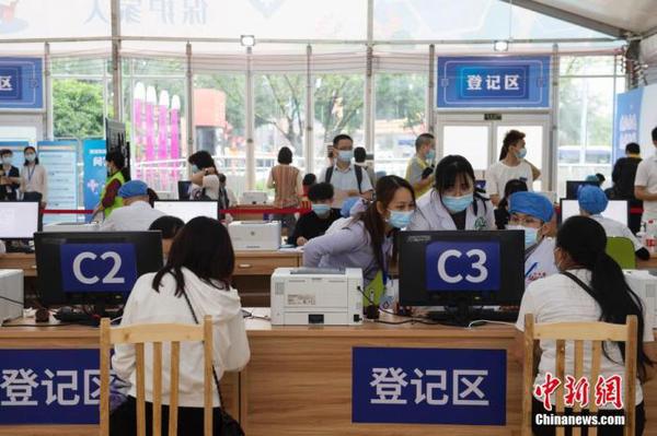 资料图：4月27日，民众在广州市天河体育中心新冠疫苗临时接种点登记区登记、确认个人信息。中新社记者 陈楚红 摄
