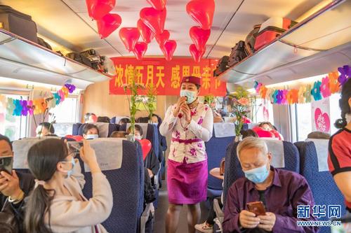 5月8日，中国铁路成都局集团有限公司重庆客运段的青年职工在C6407次列车上为旅客演唱歌曲《慈祥的母亲》。新华社记者 黄伟 摄