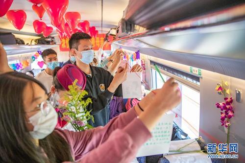 　5月8日，在万州北开往重庆北的C6407次列车上，旅客将为母亲写的祝福卡片悬挂在车厢的“祝福墙”上。新华社记者 黄伟 摄