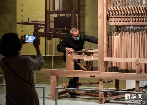 　5月18日，来自中国丝绸博物馆的工作人员在展览现场使用成都老官山汉墓出土的提花机复原品展示汉代织造技艺。新华社记者 李贺 摄