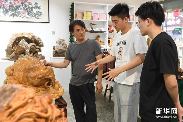 　5月24日，徐惠东（左）在位于建德市梅城镇的展厅向来自上海的游客介绍木雕作品。新华社记者 翁忻旸 摄
