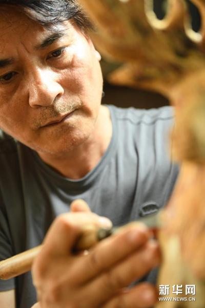 5月24日，徐惠东在位于下涯村的工作室进行木雕创作。新华社记者 翁忻旸 摄