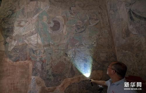 　文物专家在查看永乐宫壁画起甲、脱落、粉化等病害情况（6月21日摄）。新华社发