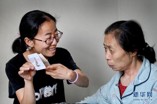杨竹梅（左）帮母亲进行语言康复训练（6月23日摄）。新华社记者 陶明 摄