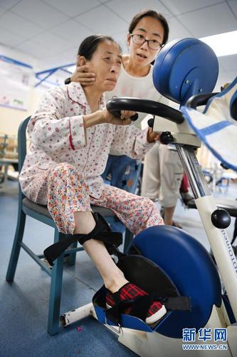 在医院的康复训练室里，杨竹梅（右）协助母亲训练（6月22日摄）。新华社记者 陶明 摄