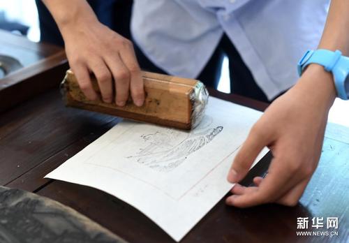 7月10日，杭州观成实验学校一名学生在展览现场体验十竹斋木版水印技艺。新华社记者 韩传号 摄