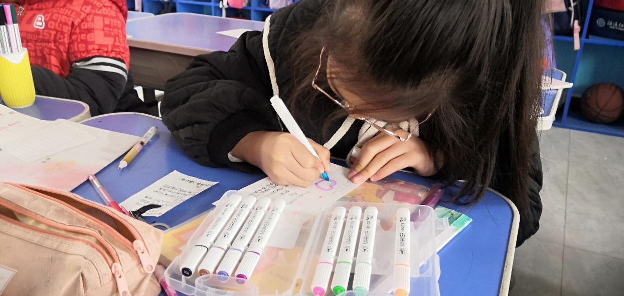巩义市米河镇中心小学的学生，正在用彩笔涂满爱心。