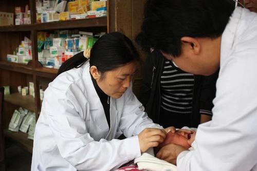 潘凤（左一）为新生儿看诊。 受访者供图